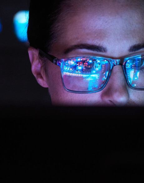 computer screen reflected in woman's glasses